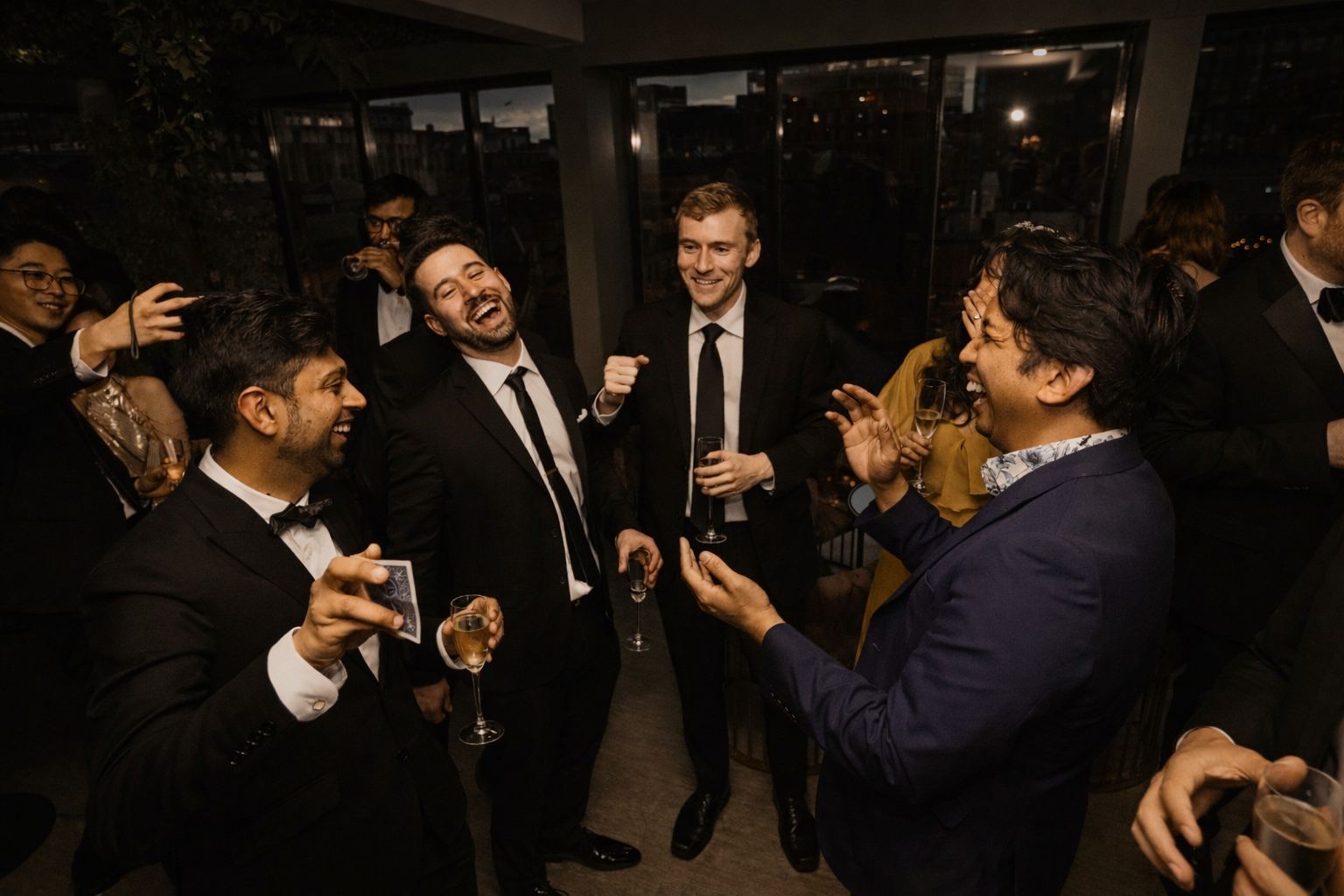 Magician performing at a corporate event, guests in black tie laughing